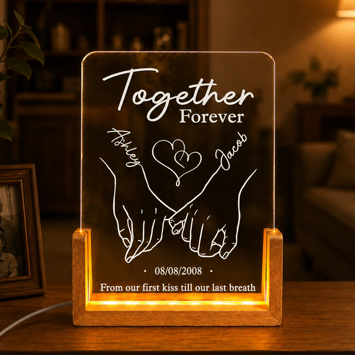 Custom anniversary night light with personalized names, holding hands art, and date on a warm wooden LED base.