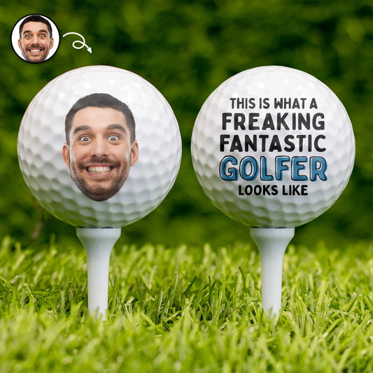 Personalized golf ball with custom photo print and funny text on tee over green grass background